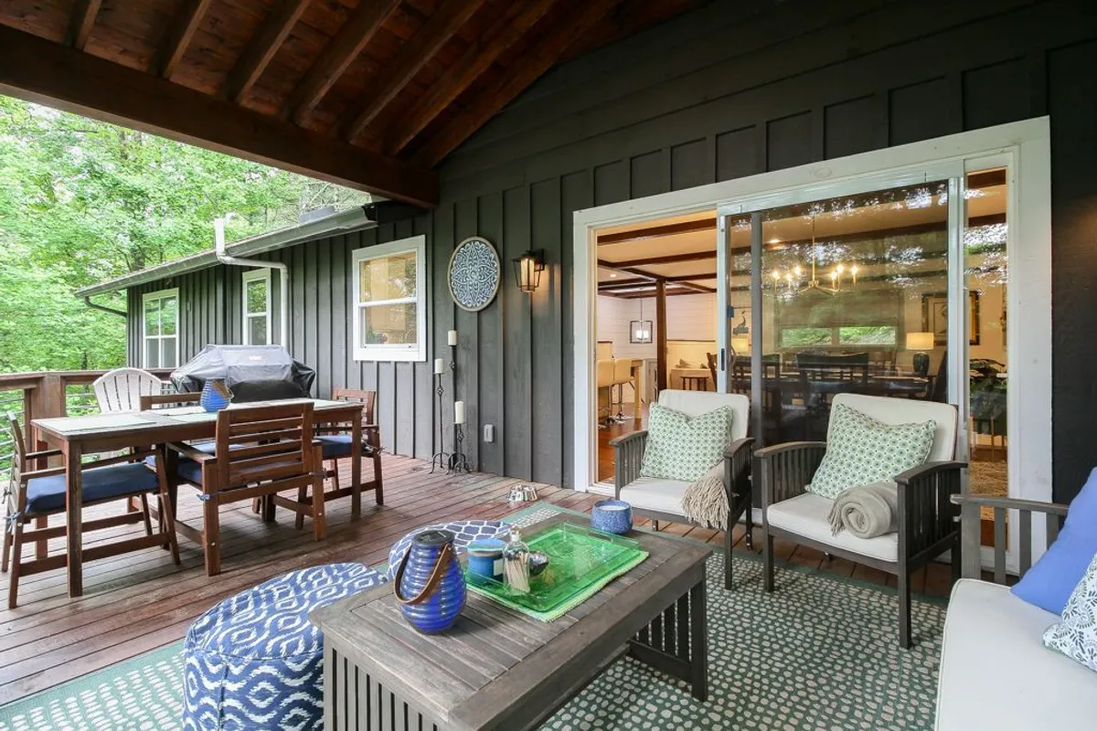 An outdoor seating area featuring a dining table and decorative wall plate, surrounded by greenery. The space is designed for relaxation, social gatherings, and enjoying nature, evoking the mood of casual comfort.